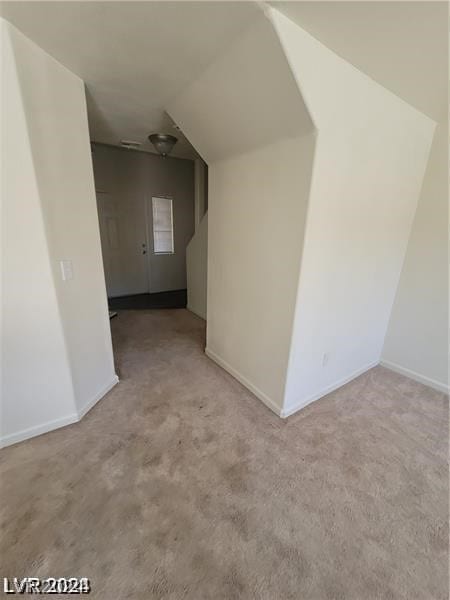 interior space with lofted ceiling and light colored carpet