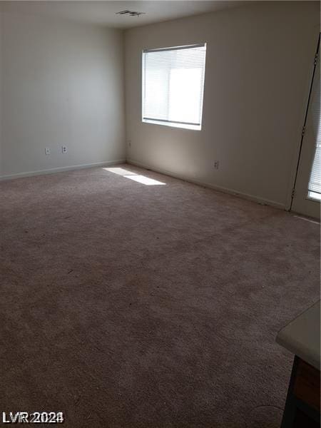 empty room featuring visible vents and carpet floors