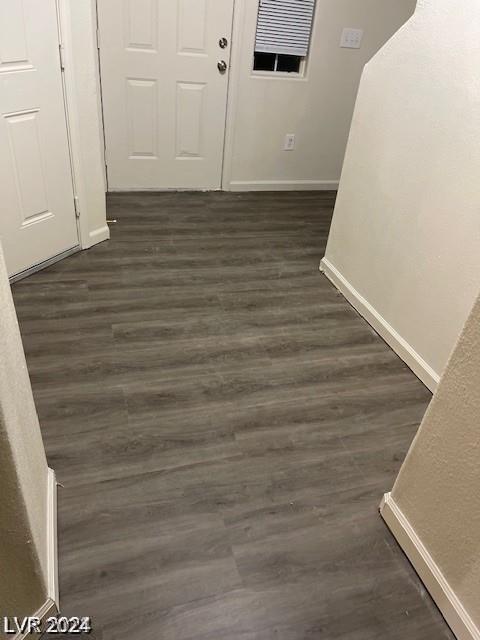 interior space featuring visible vents, dark wood-type flooring, and baseboards