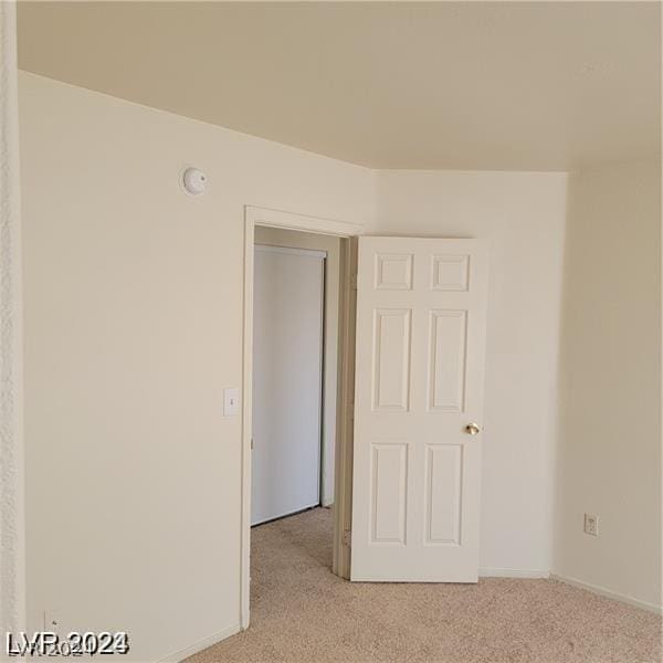 empty room with light colored carpet and baseboards