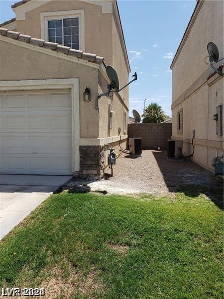 view of property exterior featuring central air condition unit, a garage, driveway, and stucco siding