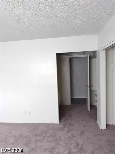 unfurnished bedroom with carpet, a closet, and a textured ceiling