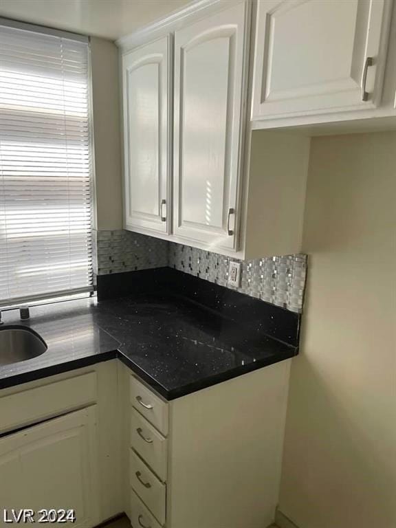 kitchen featuring white cabinetry, sink, and decorative backsplash