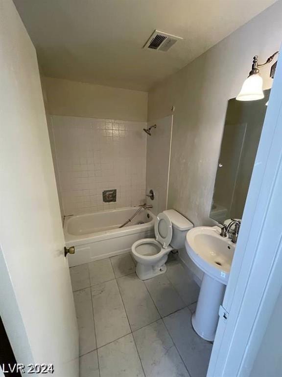 full bathroom with sink, tiled shower / bath combo, and toilet