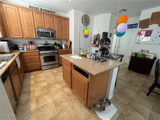 kitchen with light tile patterned floors, visible vents, brown cabinets, decorative light fixtures, and stainless steel appliances