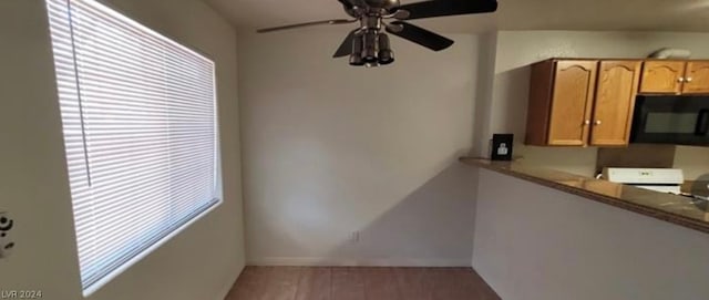 unfurnished dining area featuring ceiling fan, hardwood / wood-style flooring, and a healthy amount of sunlight