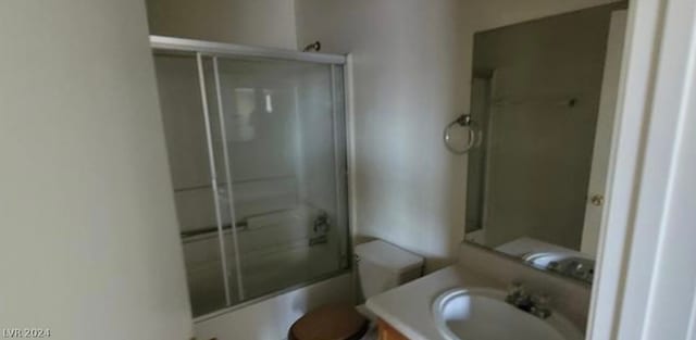 full bathroom with vanity, combined bath / shower with glass door, and toilet