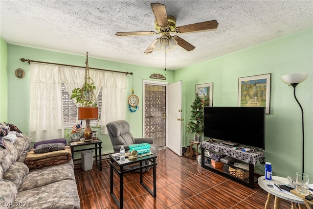 living room with ceiling fan and a textured ceiling