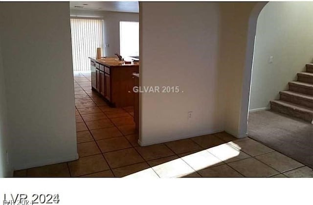 hall with sink and light tile patterned floors