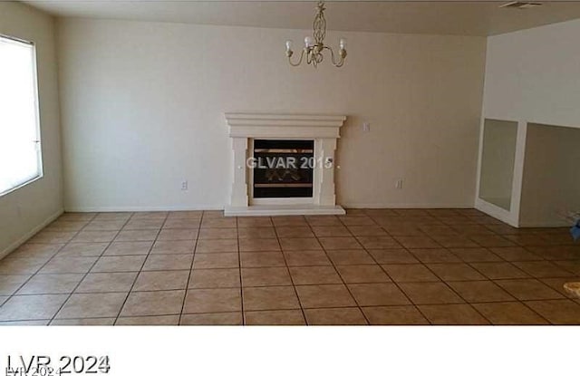 unfurnished living room featuring light tile patterned flooring and a chandelier