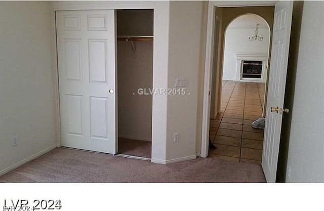 unfurnished bedroom with light carpet and a closet