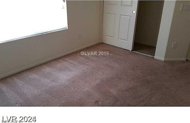 unfurnished bedroom featuring light carpet and a closet