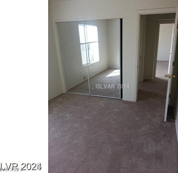 unfurnished bedroom with a closet and carpet