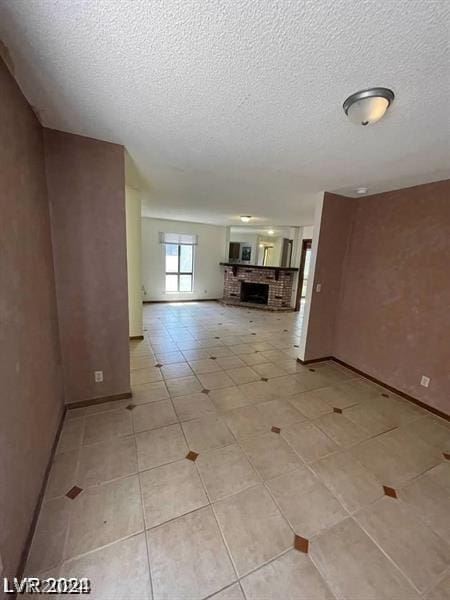 unfurnished living room featuring light tile patterned floors and a textured ceiling