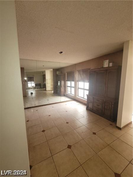 spare room featuring light tile patterned flooring and a textured ceiling