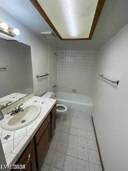 full bathroom with vanity, toilet, tiled shower / bath combo, and tile patterned flooring