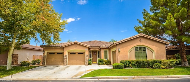 mediterranean / spanish-style home with a garage and a front lawn