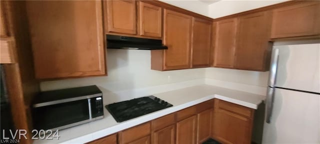 kitchen featuring fridge and black gas cooktop