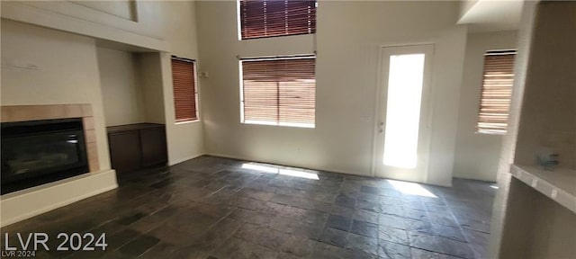 unfurnished living room featuring a towering ceiling