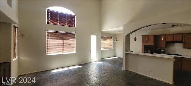 kitchen featuring pendant lighting and a towering ceiling