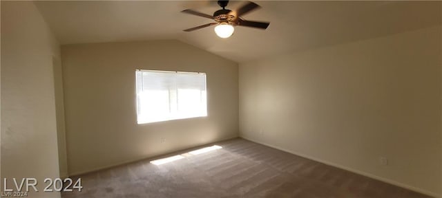 carpeted spare room featuring ceiling fan and vaulted ceiling