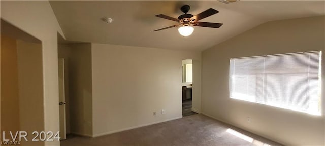 carpeted empty room featuring ceiling fan and vaulted ceiling