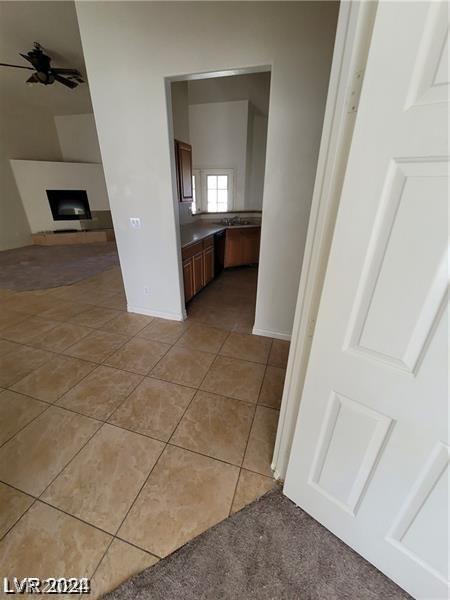 hall featuring light tile patterned floors and baseboards