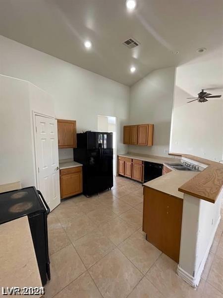 kitchen featuring visible vents, brown cabinets, a peninsula, and black appliances