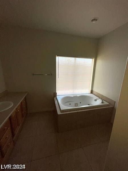 full bath with tile patterned flooring, a tub with jets, and vanity