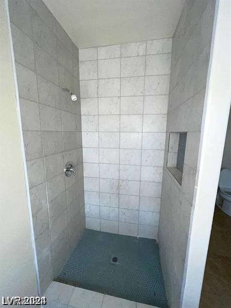 bathroom featuring toilet and a shower stall