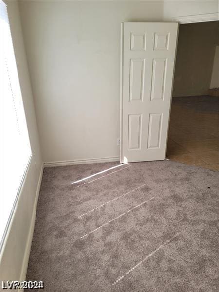 carpeted spare room featuring baseboards