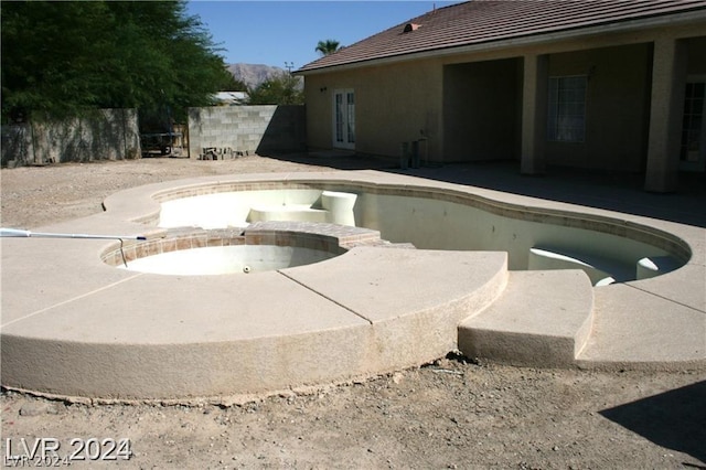 view of swimming pool with a patio, french doors, fence, and a pool with connected hot tub