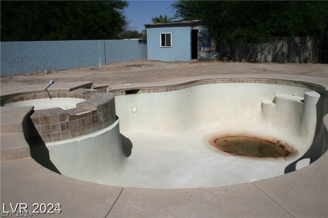 view of pool featuring an in ground hot tub and a fenced backyard