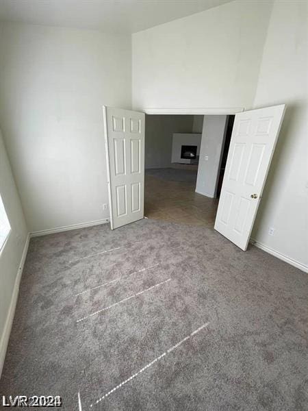 unfurnished bedroom with baseboards, carpet floors, and a fireplace