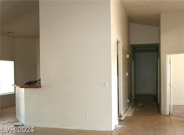 hallway featuring baseboards and light tile patterned flooring