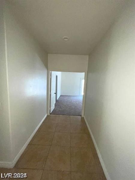 corridor featuring tile patterned floors and baseboards