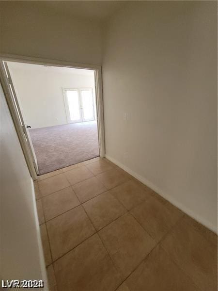 hall with tile patterned flooring and carpet flooring