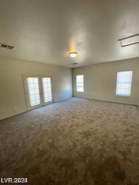 empty room with french doors, visible vents, and carpet floors