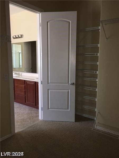 walk in closet featuring light colored carpet