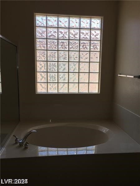 bathroom with a tub to relax in