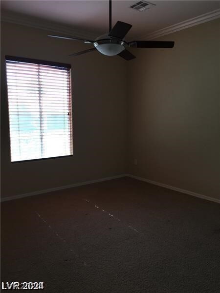 carpeted spare room featuring crown molding and ceiling fan