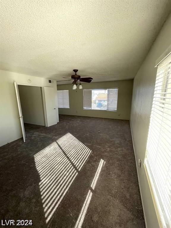 interior space featuring ceiling fan, plenty of natural light, and a textured ceiling