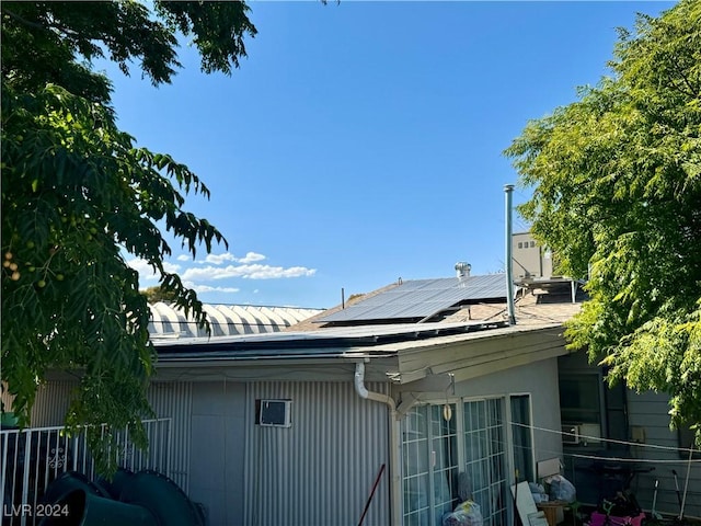 view of side of property featuring solar panels