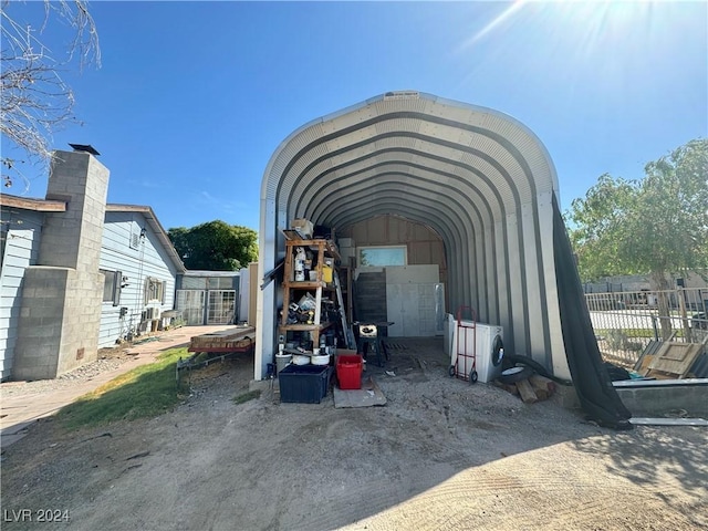 view of outbuilding featuring a carport and fence