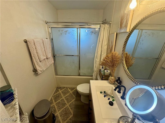 bathroom featuring toilet, enclosed tub / shower combo, and vanity