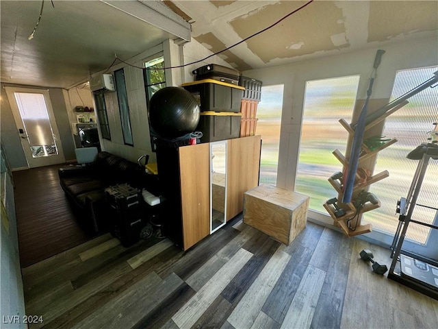 interior space featuring wood finished floors and an AC wall unit