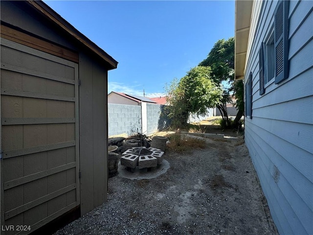 view of yard featuring an outdoor fire pit and fence