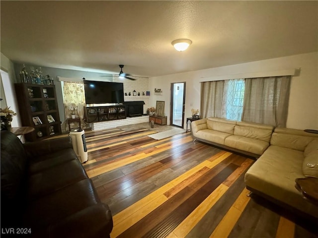 living area featuring a fireplace, ceiling fan, and hardwood / wood-style floors