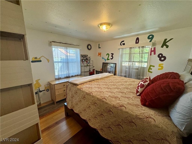 bedroom with a textured ceiling and hardwood / wood-style floors