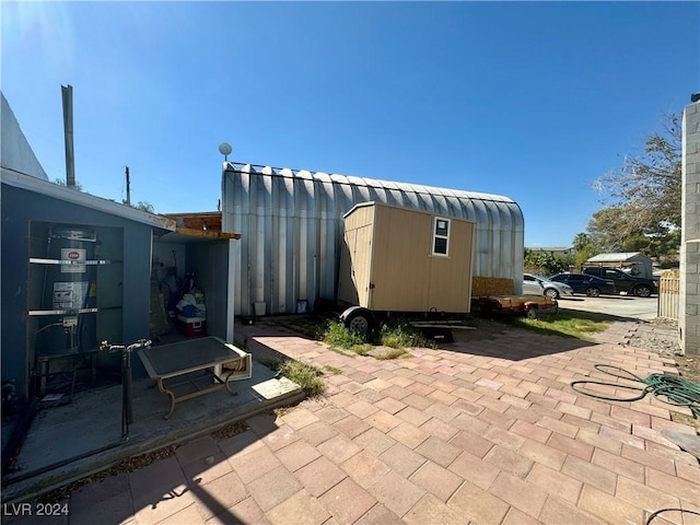 view of patio with an outbuilding and a shed